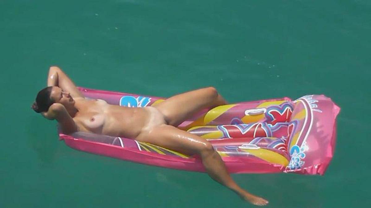 Olhar convidativo em vídeo de garota nudista flutuante