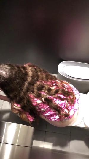 Voyeur kneels to peep on pissing in public toilet