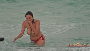 Amazing topless woman bends over on the beach