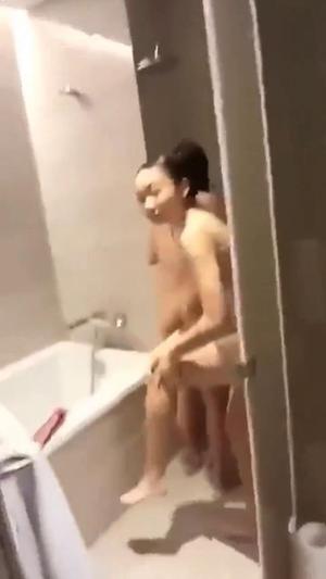 Peeping above wall to see naked asian girl in bathroom